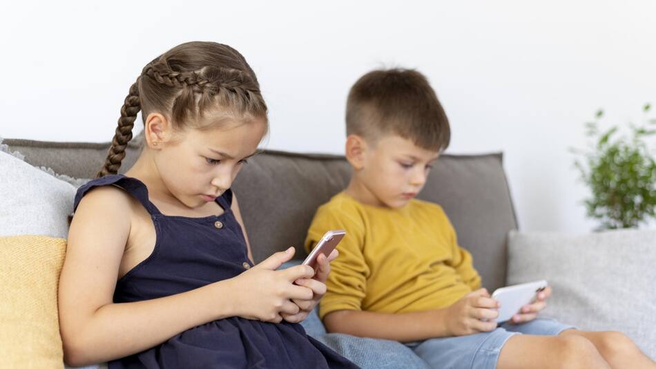 Niños usando el celular. Foto FREEPIK