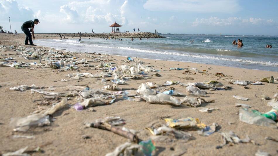En la imagen de archivo, un voluntario retira la basura que se acumula en la orilla de la playa Sanur en Bali (Indonesia). EFE/ Made Nagi