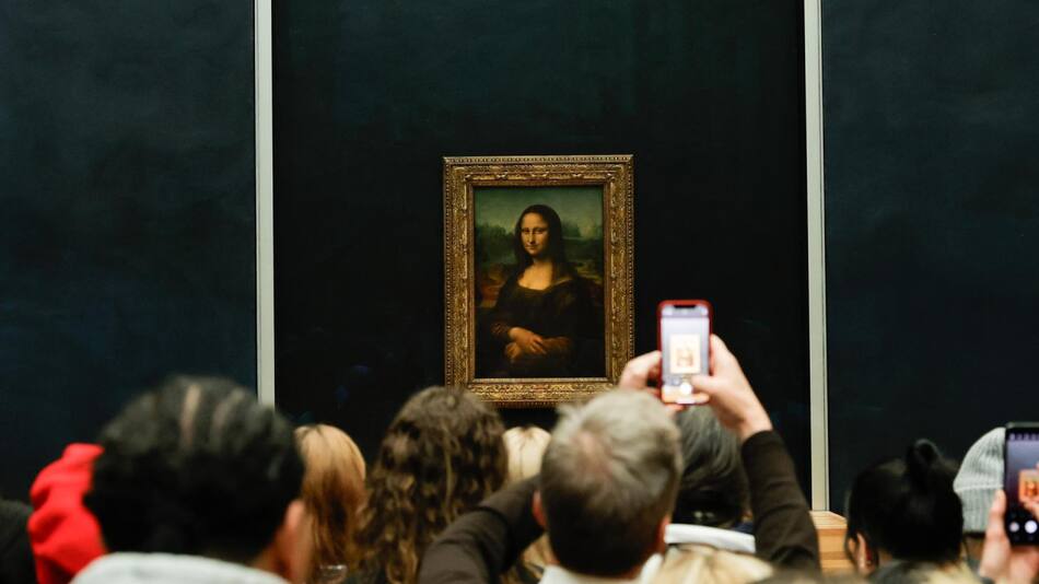 Visitantes toman fotografías de la Mona Lisa del pintor italiano Leonardo Da Vinci en el Museo del Louvre en París, Francia. EFE